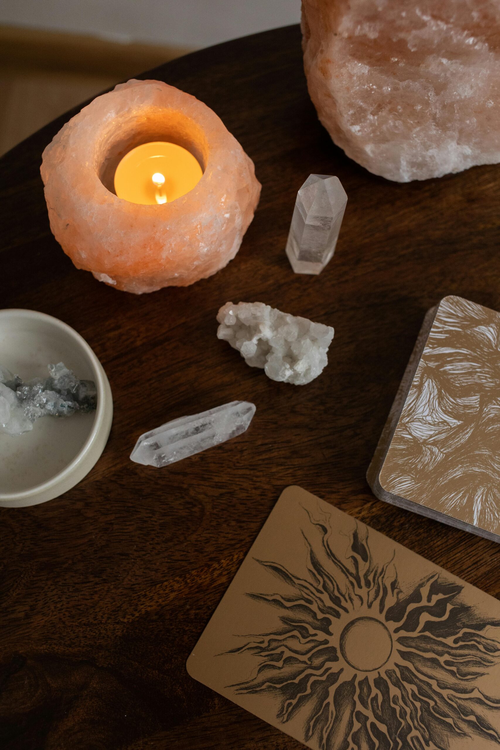 Home A serene top view of crystals, a candle, and esoteric cards on a wooden table.
